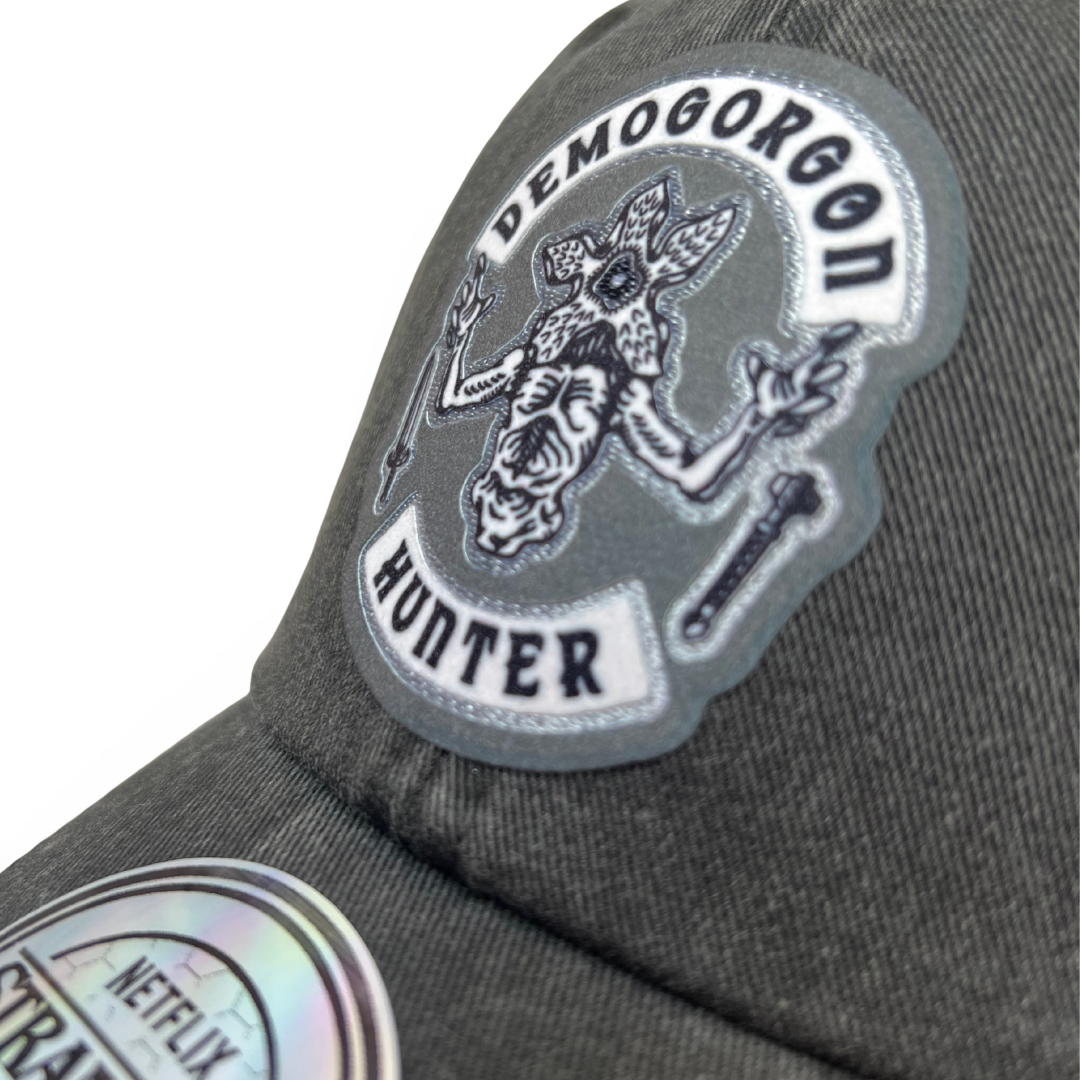 Gorra Stranger Things Emblema de Caza-Demogorgones Gris Tipo Deslavada