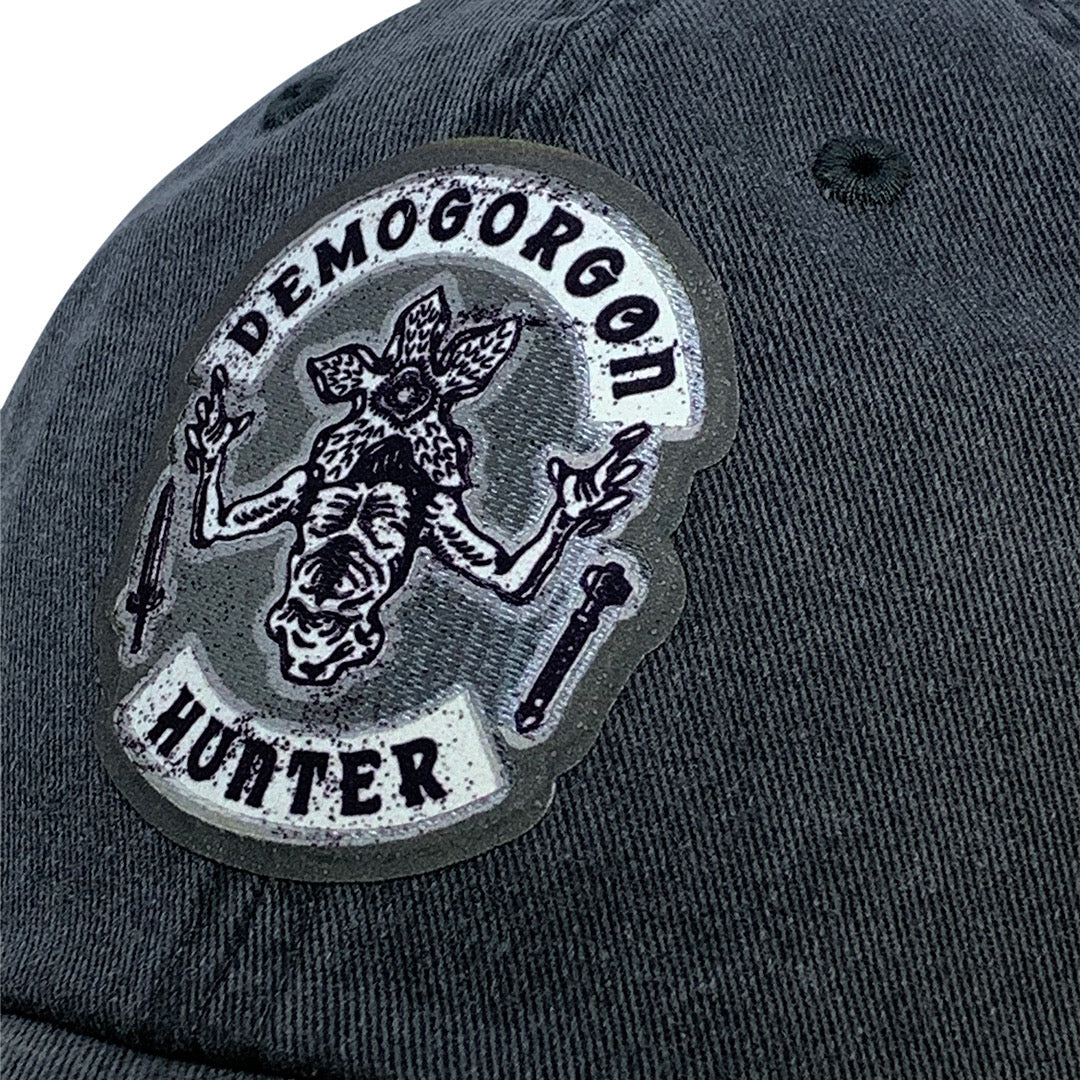 Gorra Stranger Things Emblema de Caza-Demogorgones Gris Tipo Deslavada