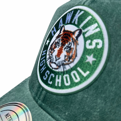 Gorra Stranger Things Emblema Preparatoria Hawkins Verde/Blanca Tipo Trucker Deslavada
